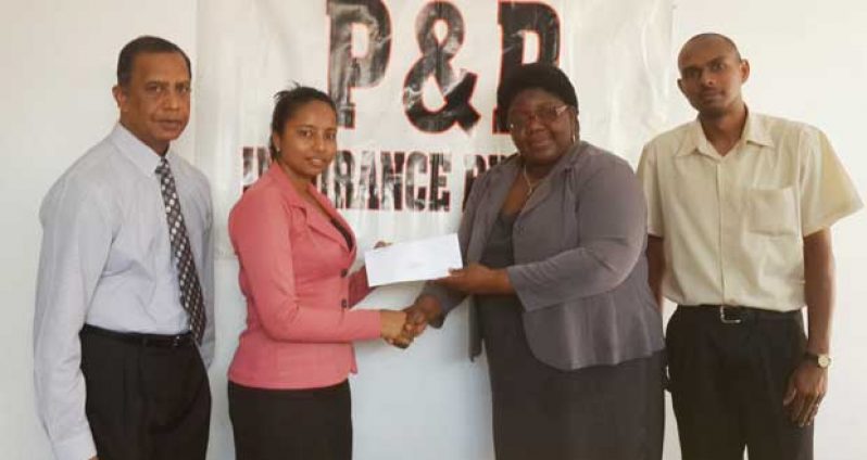 Supervisor of Universal Solutions of New Amsterdam, Berbice Christopher De Souza (right) makes the presentation to Steve Deonarine, on behalf of his Chief Executive Officer Vicram Seubarran.