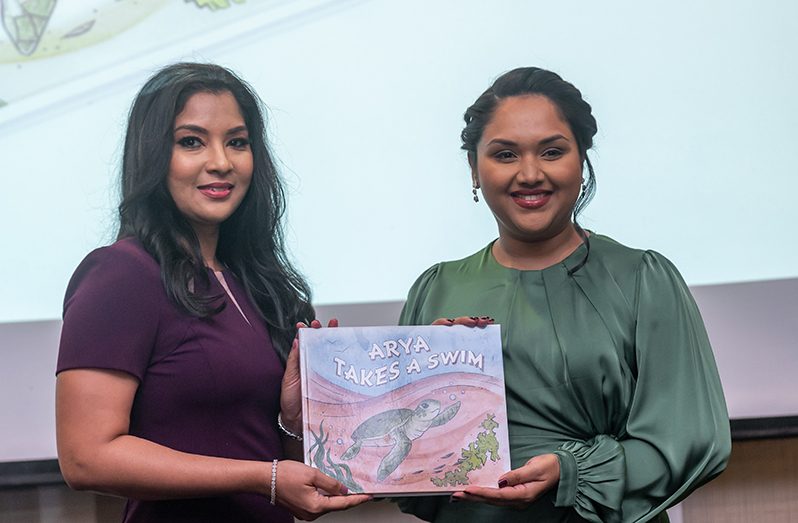 First Lady of Guyana, Arya Ali (right), receives a copy of the book named after her from an EMC representative (Delano Williams photo)