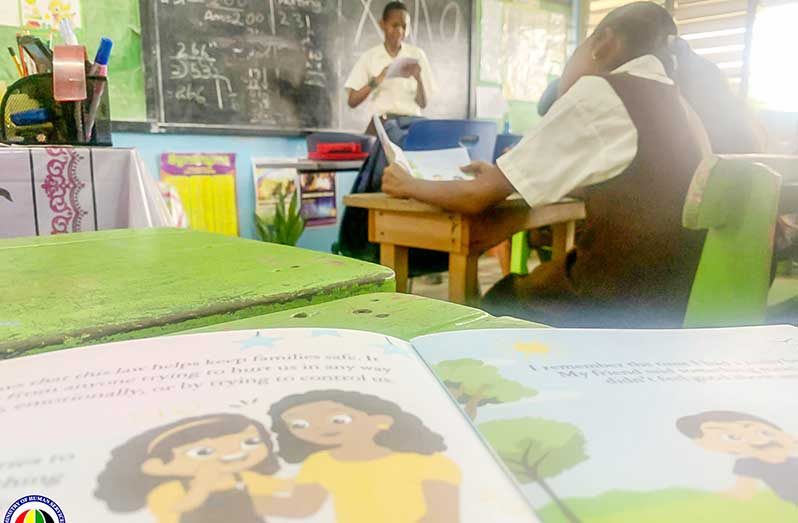 Primary school students reading the book, distributed by the Ministry