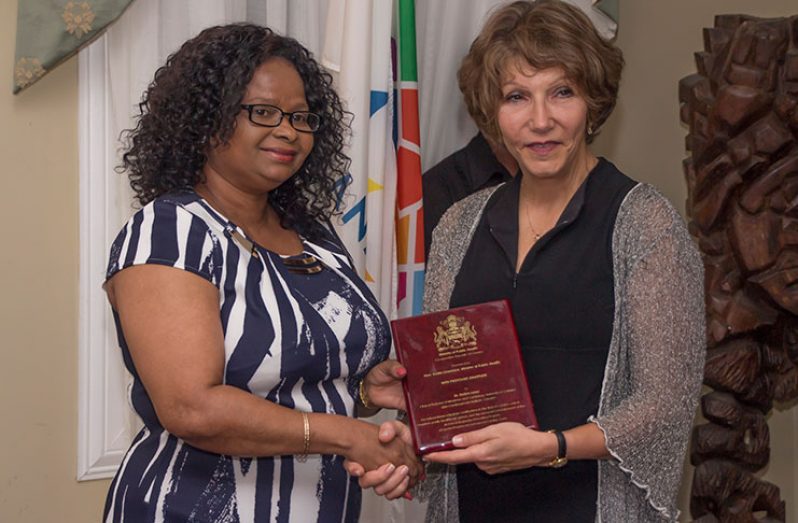 Minister of Public Health, Volda Lawrence, hands over a token of appreciation to the Co-Director of the Guyana Programme to Advance Cardiac Care (GPACC) Dr Debra Isaac
