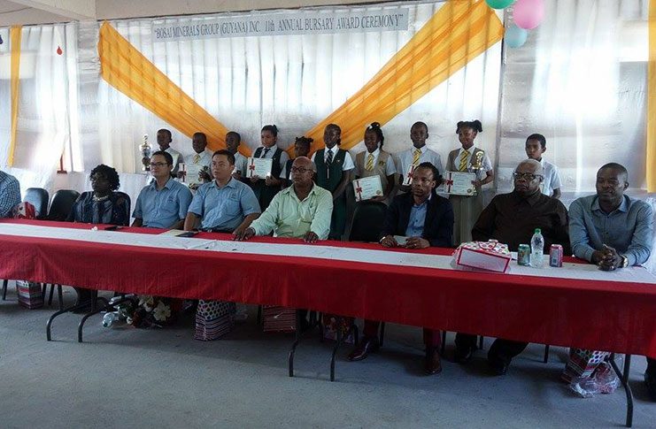 Some of the top National Grade Six Assessment Achievers posing with their certificates (from-left) at the head table are Mayor of Linden Carwyn Holland, Head of Nicil Horace James Member of Parliament Jermaine Figueira, Chief Engineer of Bosai Orin Barnwell, General Manager of Bosai Robert Shang and other employees of Bosai