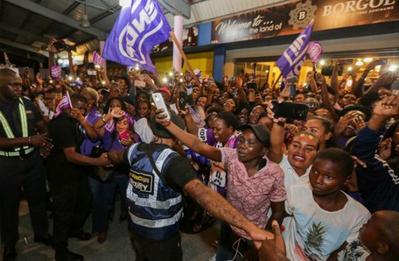 Supporters of Suriname's President Desi Bouterse (not pictured), who was convicted of murder for the execution of opponents by a court in Suriname, cheer upon his arrival from China, in Paramaribo, Suriname December 1, 2019. REUTERS/Ranu Abhelakh