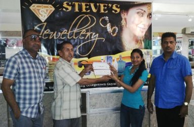 A representative of Steve’s Jewellery (second right) presents the two bracelets to president of the GFSCA, Ramchand Ragbeer, in the presence of GFSCA vice-president Ricky Deonarain (left) and proprietor of Steve’s Jewellery.