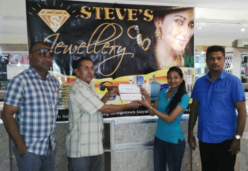 A representative of Steve’s Jewellery (second right) presents the two bracelets to president of the GFSCA, Ramchand Ragbeer, in the presence of GFSCA vice-president Ricky Deonarain (left) and proprietor of Steve’s Jewellery.