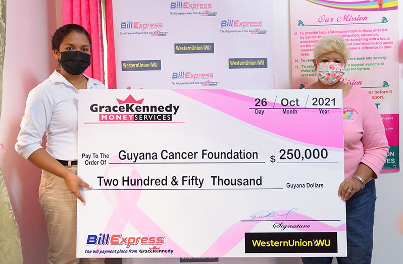 Tina Seabra-Gibson, Marketing Assistant-Western Union/Grace Kennedy Money Services and Founder and President of the Guyana Cancer Foundation, Bibi Hassan, holding the cheque (Delano Williams photo)