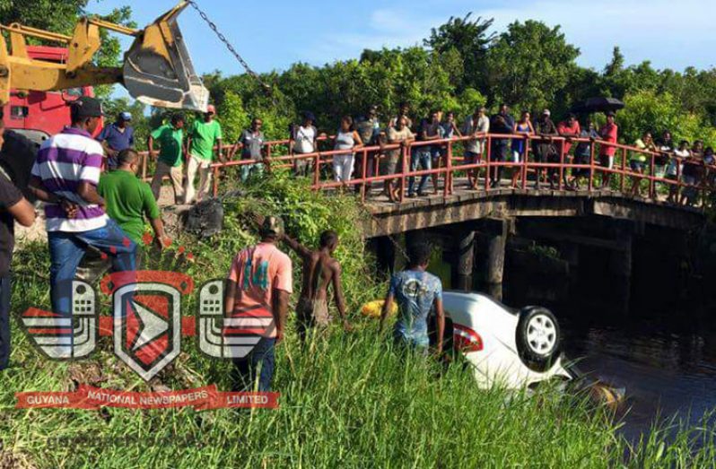 Residents of Capoey rush to assist the occupants of the vehicle who were trapped after it ended up overboard on Saturday.