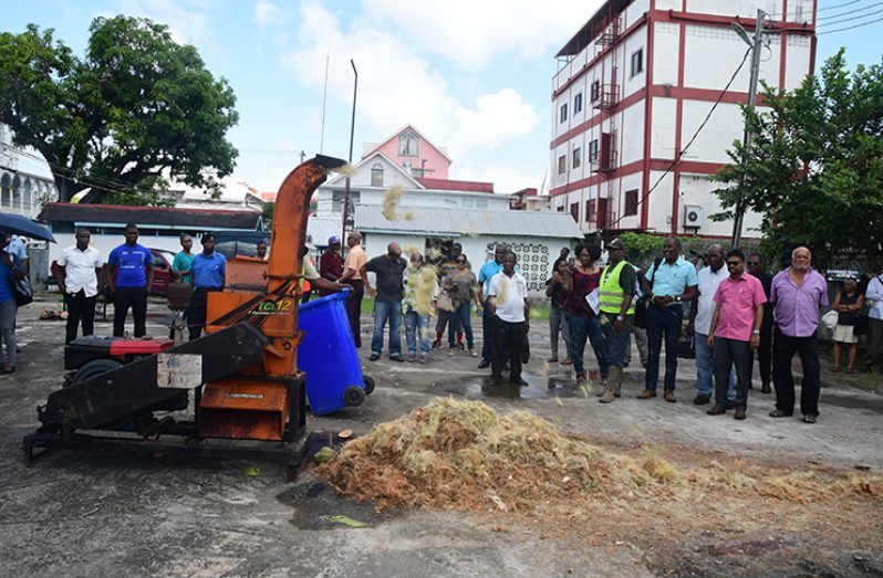 Mayor Ubraj Narine, along with members of the Georgetown City Council and Guyana Coconut Industry Developers, Co-operative Society Limited (GCIDCO) viewing coconut waste being shredded