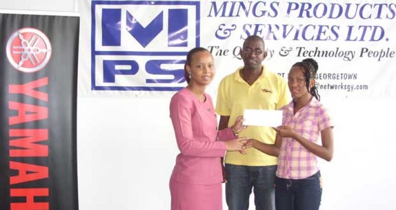 Cassie George receives her cheque from the company’s Human Resources Personnel Alesa Bacchus while her coach Moses Pantlitz, looks on.