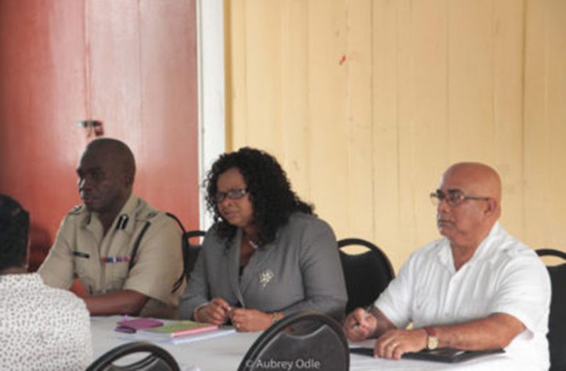 Lawrence flanked by Commander Leslie James and REO Denis Jaikaran