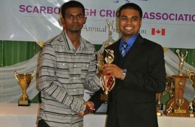 HACC skipper Hemnarine Chattergoon (left) collects the championship trophy from SCA registrar/statistician Shiv Persaud
