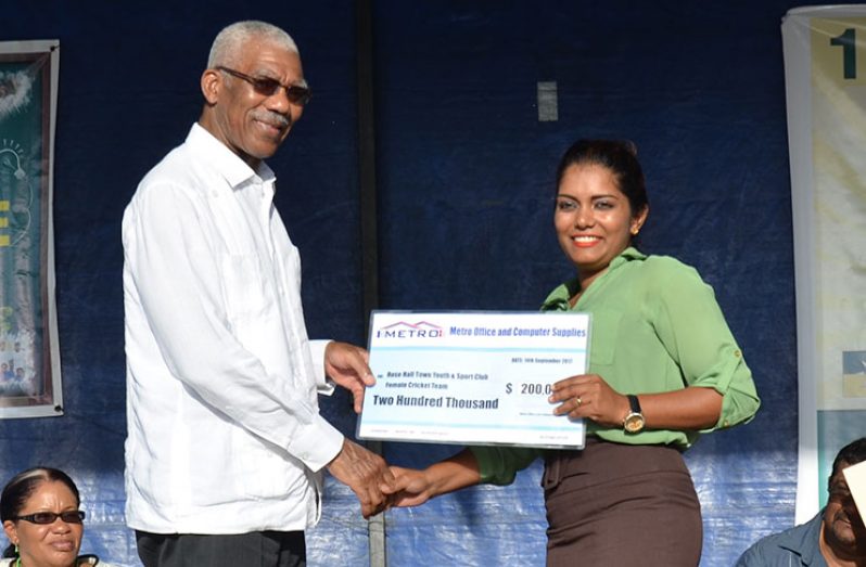 Fhaleeza Ramcharran of Metro Office Supplies presents cheque to RHTY&SC Patron, His Excellency President David Granger.