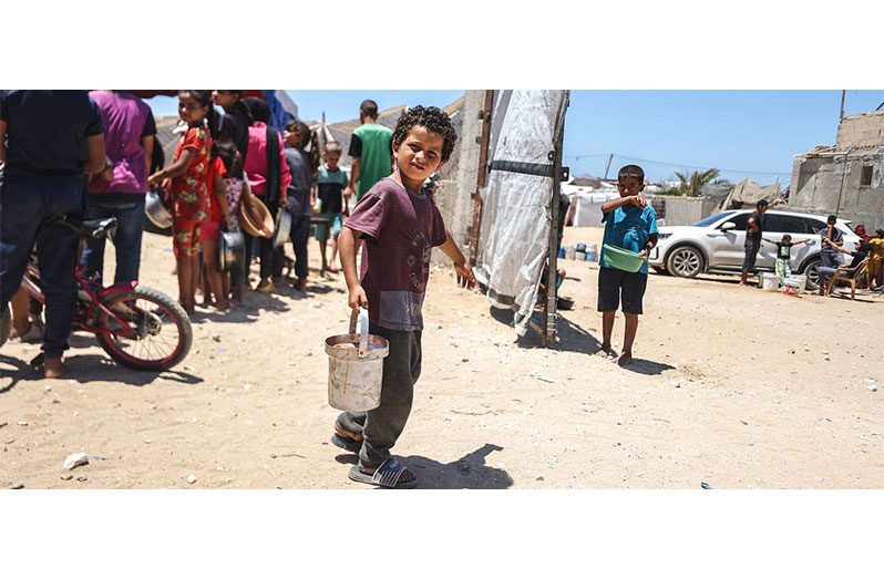 A child receives food at a WFP-supported kitchen in Khan Younis, Gaza (WFP/Ali Jadallah photo)