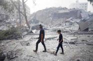 A child and his father as they pass through the rubble of buildings in Gaza (UNICEF/UNI448939/Eyad El Baba)