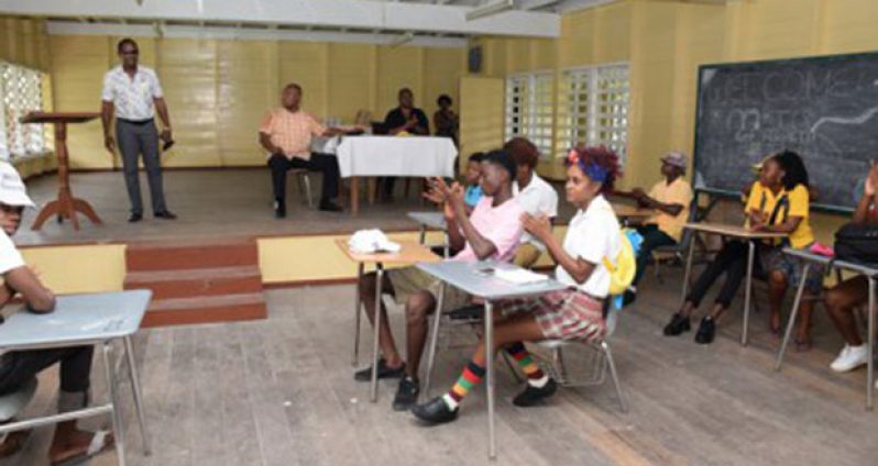 Police ‘A’ Division Commander Clifton Hicken (standing) looks on as young people of East Ruimveldt perform a skit at launch of police youth group