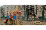 A children’s playground in front of a heavily damaged residential building in Kharkiv (UNICEF/Stas Bilyk)