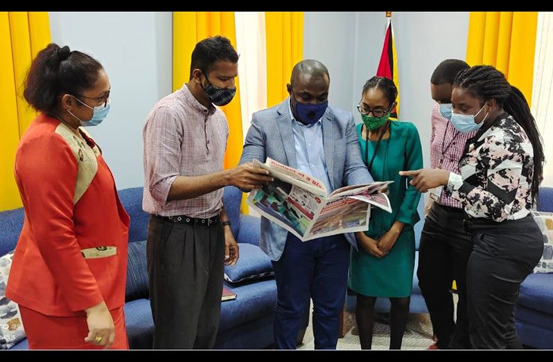 Minister within the Prime Minister’s Office, Kwame McCoy (third left) examines a copy of the Guyana Chronicle Quarterly, as General Manager of the Guyana National Newspapers Limited, Moshamie Ramotar (left) and Editor-in-Chief, Tajeram Mohabir (second left) pay keen attention. Also in the photograph are, Advertising Clerk, Sarah Boyce; Reporter, Jared Liddell; and Senior Reporter, Tamica Garnett, fourth, fifth and sixth left, respectively
