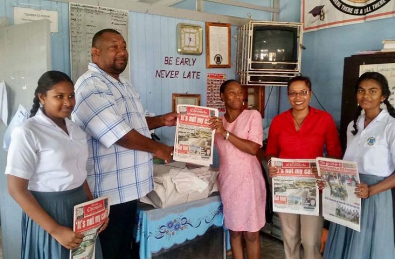 Director of the Guyana National Newspapers Limited Hilbert Foster ( second left) hands over a copy of the Guyana Chronicle to Headmistress (Ag)Sharon Hawks of the Lower Corentyne Secondary,Students  and Acting Deputy HM Chandra Baichoo 