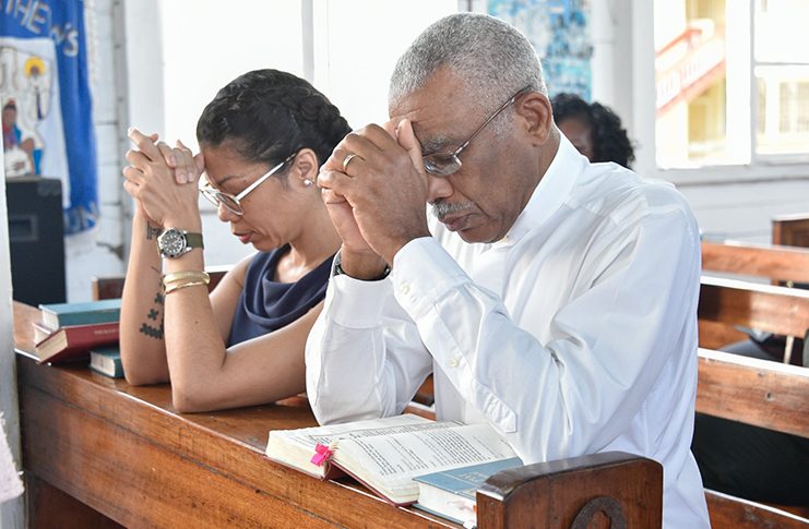 President David Granger and his daughter, Afuwa, praying during this morning's Christmas Day Mass at St. Matthew's Parish Church.