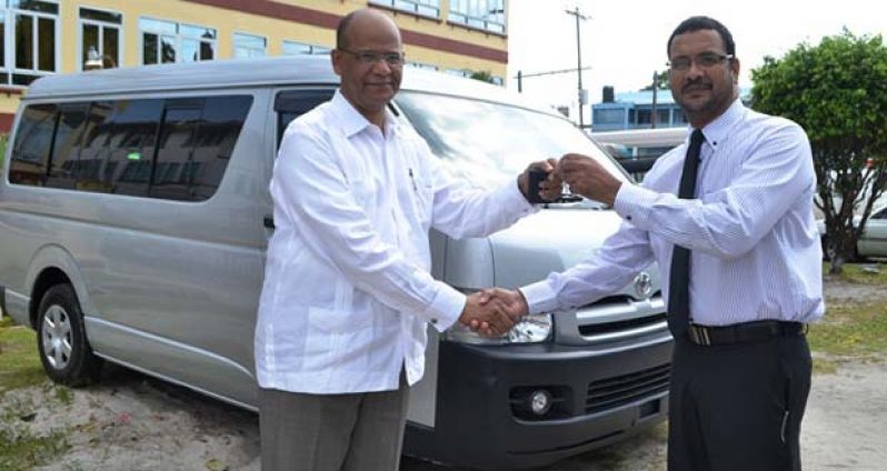 Minister Clement Rohee presenting the keys to the new vehicle to Head of the Customs Anti-Narcotics Unit, James Singh