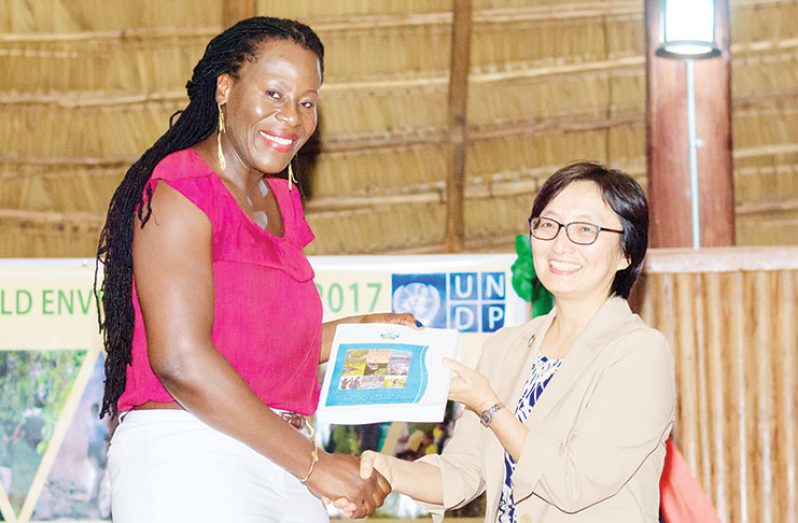 Director of the Department of Environment Ndibi Schwiers receives her copy of the report from UN Resident Rep. Mikiko Tanaka (Delano Williams photo)