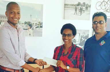 All Smiles! Proprietor of German’s Restaurant Clinton Urling handing over donation to Nia Gonsalves, Captain of the Kanimas Women Baseball team with Guyana’s head for Baseball, Robin Singh looking on.