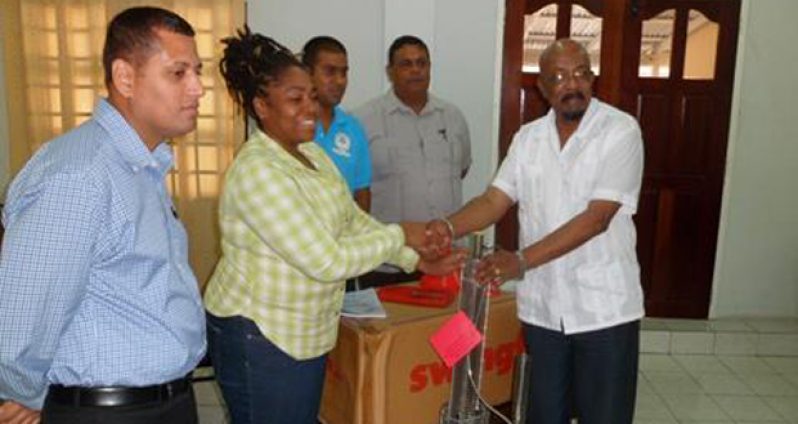 Dr. Nadia Coleman receives fogging machine on behalf of RDC Region 3 from Minister Norman Whittaker