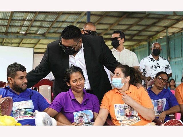 President, Dr. Irfaan Ali comforts the family of young Aiden Kiritpal (Office of the President photo)