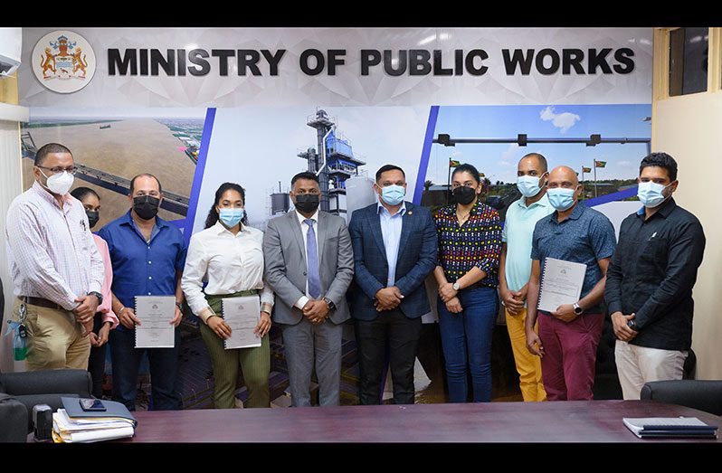 Minister within the Ministry of Public Works, Deodat Indar; Natural Resources Minister, Vickram Bharrat (centre), and the contractors following the simple signing ceremony (Delano Williams photo)