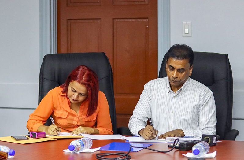 Ministry of Labour’s Permanent Secretary Bishram Kuppen and owner of Perba Trading and Construction signing the $23.7M contract (DPI photo)