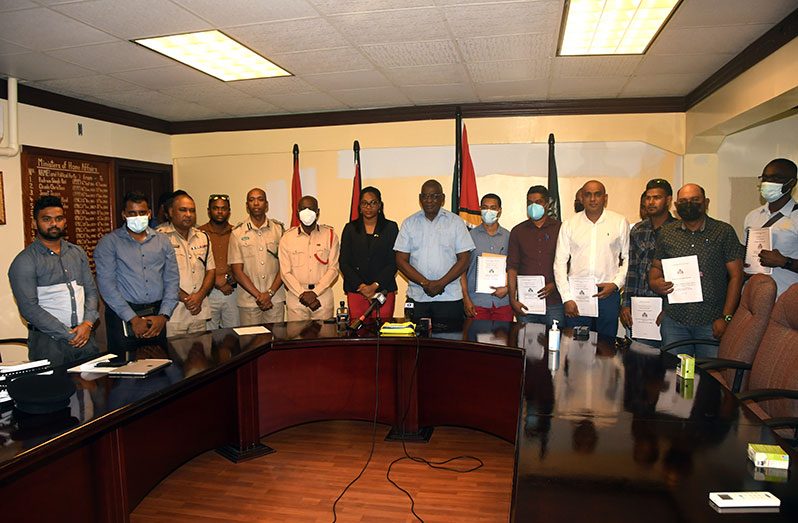 Representatives of the various companies, along with Deputy Commissioner Operations of the Guyana Police Force, Ravindradat Budhram (third from left), Director of the Guyana Prison Service, Nicklon Elliott (fifth from left) and Fire Chief (ag) Gregory Wickham (sixth from left) flank Minister of Home Affairs, Robson Benn and Permanent Secretary, Mae Toussaint Jr Thomas (both standing at centre) (Adrian Narine photo)