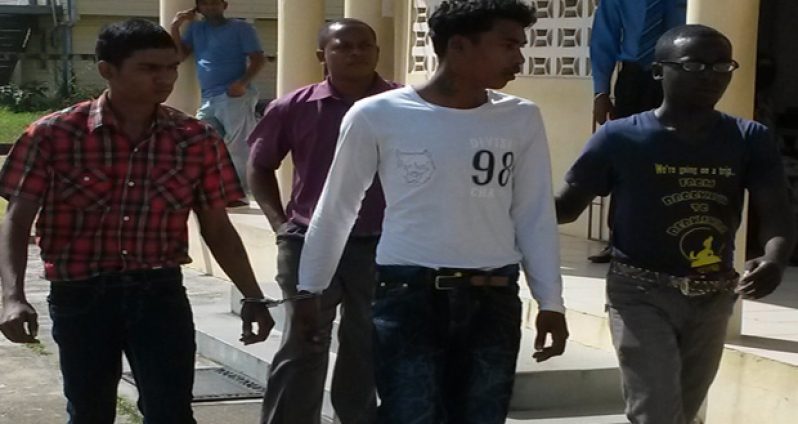 Alleged killers Nazamadeen Raffick, 19, (left) and Gocoul Madanpaul, 18,  (right) being escorted  to the lockups after their brief appearance at the Fort Wellington Magistrate court yesterday