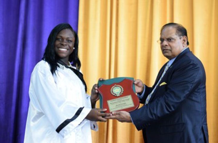Sherlyn Semple of the New Amsterdam Multilateral School receives a plaque for being one of the best graduating students