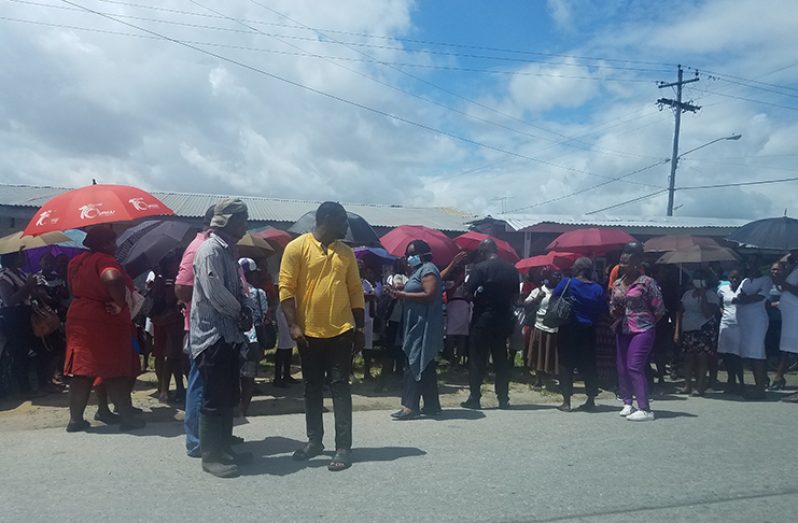 Regional Executive Officer, Jennifer Ferreira-Dougall (with face mask) meeting with staff gathered outside the West Demerara Regional Hospital on Friday (Tamica Garnett photo)