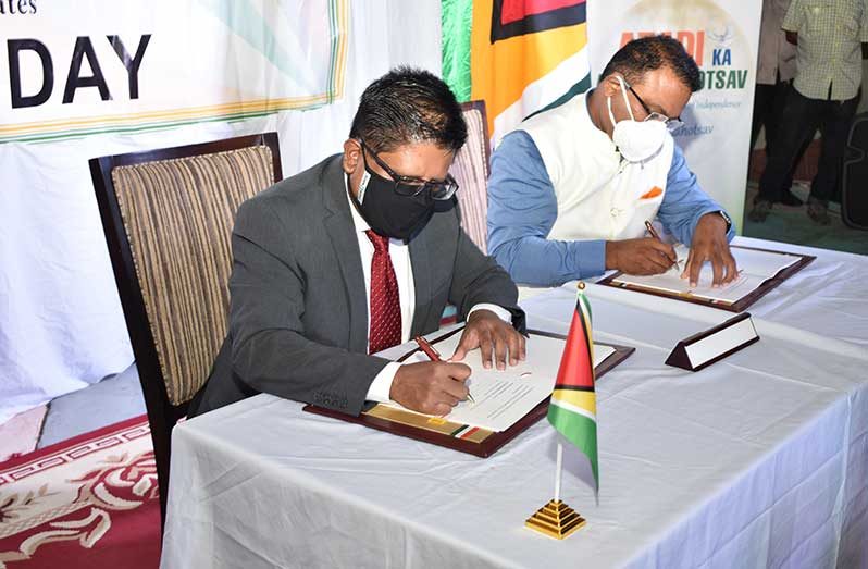 Senior Minister in the Office of the President with responsibility for Finance, Dr Ashni Singh (left) and Indian High Commissioner to Guyana, Dr. K. J. Srinivasa sign the Line of Credit agreement (Elvin Croker photo)