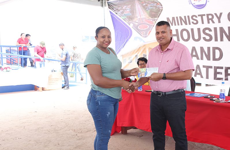 Minister of Housing and Water, Collin Croal, handing over Steel and Cement Housing Subsidy vouchers to Region Nine residents