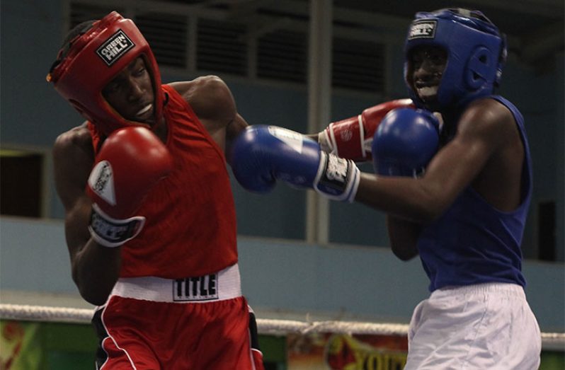 Guyana’s Mark Crawford connects with a crushing left against Barbados boxer Tyree Taitt.
