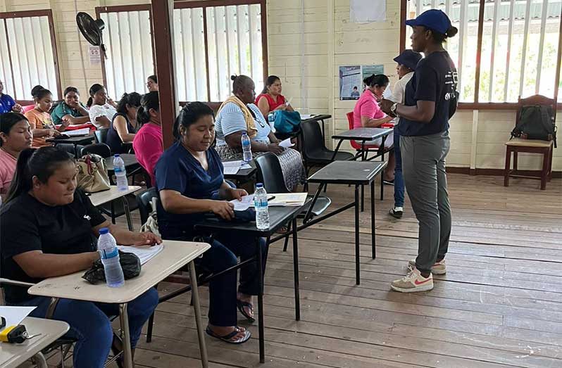 A member of the C-TIP Unit engages residents of Mahdia during an anti-trafficking outreach (Photo: MHSSS/ Facebook)