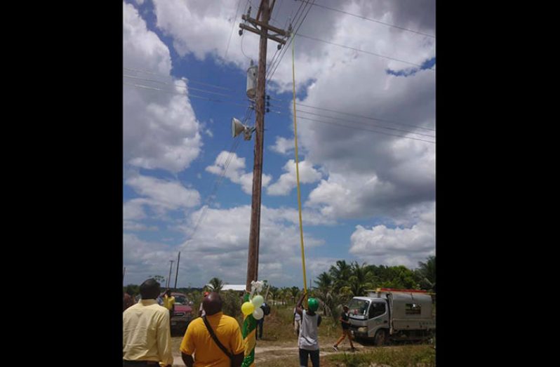 One of the main electricity posts in Andyville being switched on as regional officials look on