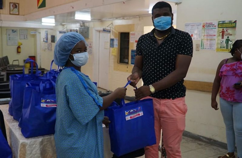 Star Party Rental Operations Manager Vyphuis hands over a hamper at Mahaicony Hospital