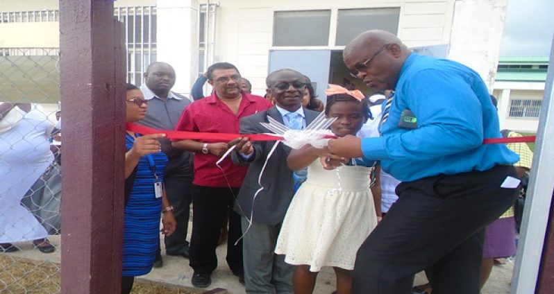 New Amsterdam Regional Hospital Chief Executive Officer Colin Bynoe assists a patient of the Paediatric Ward to cut the ceremonial ribbon for the opening of the playpark. Also in photo are PAHO/WHO Country Representative Dr William Adu-Krow, and Region Six Chairman David Armogan