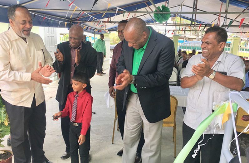Minister of State Joseph Harmon; EPA Director, Dr. Vincent Adams; EPA Board Chairman, Dr.Patrick Williams and others applaud this young boy who cut the ceremonial ribbon to officially open the EPA Berbice Office
