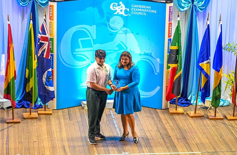 Minister Priya Manickchand hands over an award to CSEC Overall Top Performer Alex Muntaz of the Anna Regina Secondary School