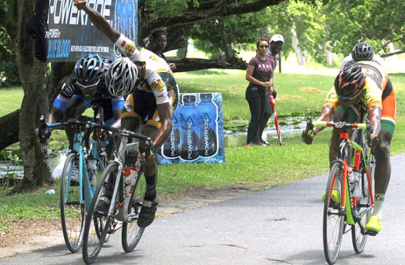 Trojan PSL’s Curtis Dey (arm raised) clinches victory by half of a wheel ahead of Jamual John (right) and Andrew Hicks (left). (Adrian Narine photo)