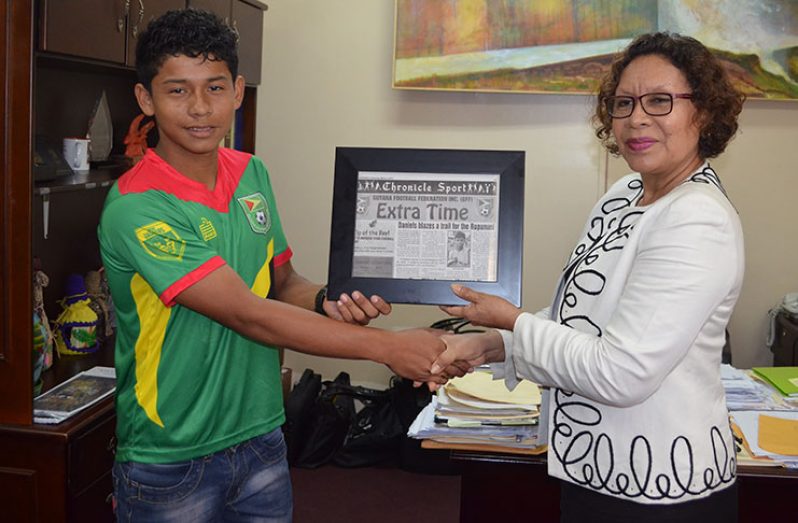 Minister Valerie Garrido-Lowe presents a framed copy of GFF's ‘ExtraTime’ to Daniels.