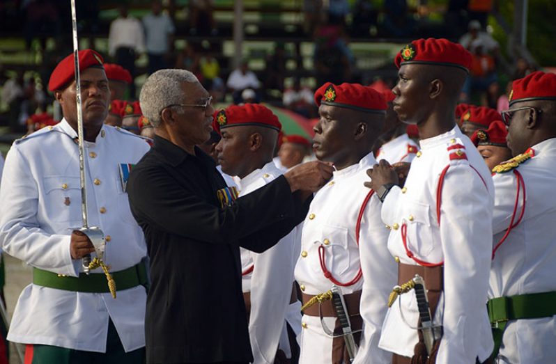 President David Granger is assisted by Brigadier Patrick West of the GDF, as he decorates Reserve Officer, 2Lt. Ivor Semple with his new badge of rank