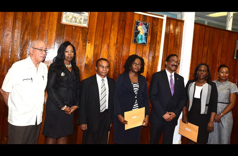 Second from right, Chairwoman Christine McGowan and Minister Basil Williams are flanked by other board members and registrars of the Deeds and Commercial Registries.