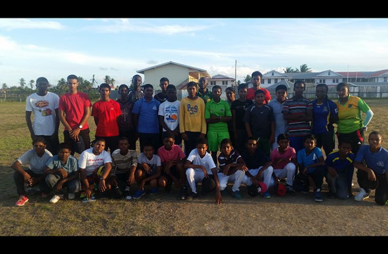 Coach Delbert Hicks poses with some of his young cricketers.