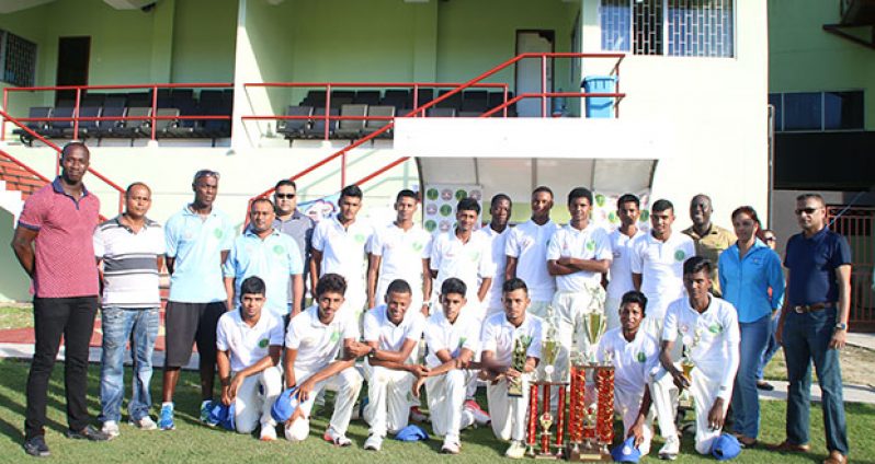 The victorious Demerara Under-19 team pose with their respective trophies. GCB Secretary Anand Sanasie is far left while Hand-In-Hand Marketing Representative Savita Singh is at far right.