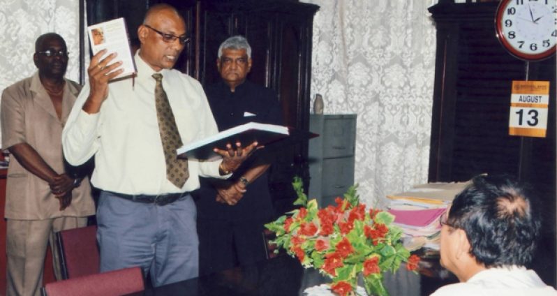 Mr. Vishnu Persaud, Deputy Chief Election Officer/Deputy Commissioner of Registration taking the Oath of Office, for the position of Deputy Commissioner of Registration, which was administered by Chief Justice Ian Chang (seated).  Looking on is Dr. Steve Surujbally (third from left), Chairman of GECOM and Mr. Keith Lowenfield, Chief Election Officer (extreme left).