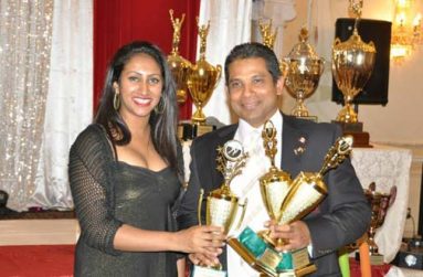 Former Guyana player Sunil Dhaniram collects three trophies from the OMSCL president’s daughter, for scoring three centuries